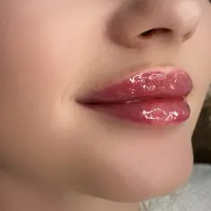 Błyszczące, pełne usta baby doll po zabiegu makijażu permanentnego.